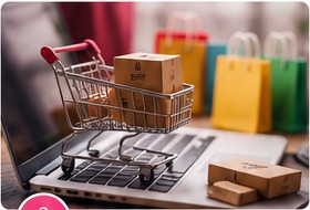 Shoppingvagn och paket framför en laptop